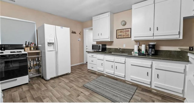 kitchen with white cabinets, sink, and white appliances