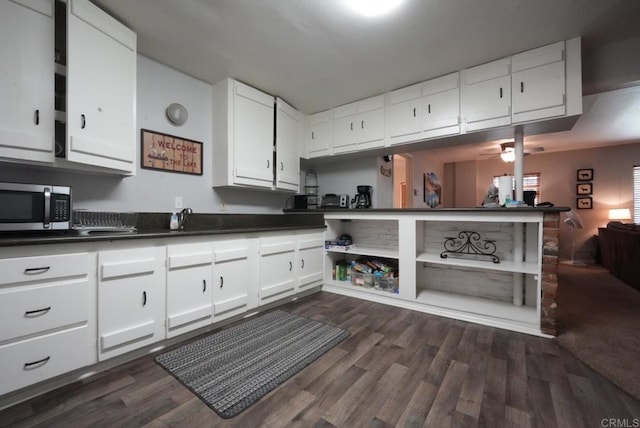39414 Ruby Ln, Big Bear Lake, CA 92315 - kitchen featuring stainless steel microwave, dark countertops, dark wood-style floors, and white cabinets