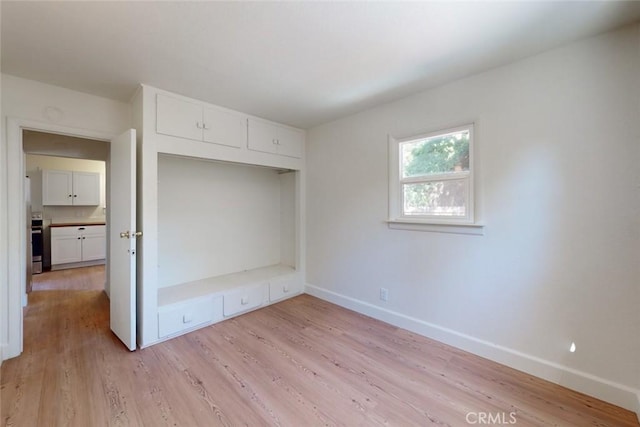 unfurnished bedroom featuring light hardwood / wood-style flooring and a closet