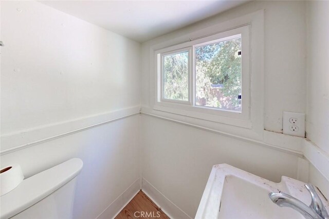 bathroom featuring toilet, sink, and hardwood / wood-style floors