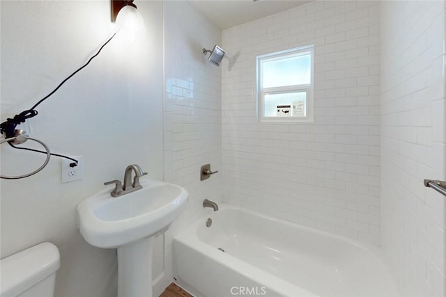 full bathroom with toilet, tiled shower / bath combo, and sink