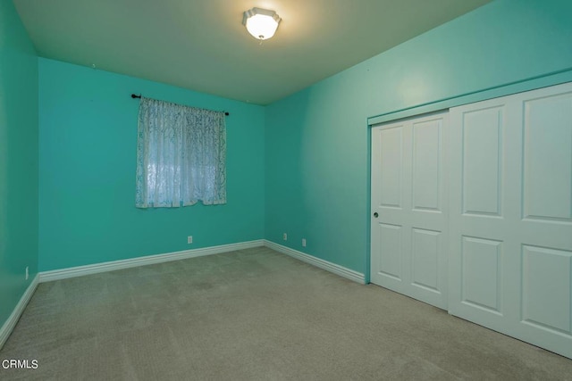 unfurnished bedroom with light carpet and a closet