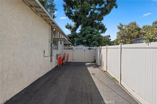 613 E Chapman Ave, Fullerton, CA 92831 - view of asphalt driveway with a gate