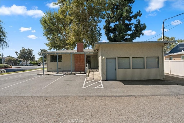 613 E Chapman Ave, Fullerton, CA 92831 - view of front of property with a chimney, stucco siding, uncovered parking, and fence