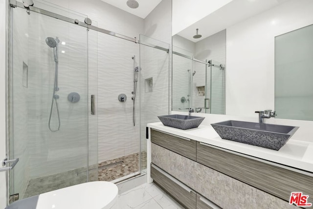 bathroom featuring a shower with door, vanity, and toilet