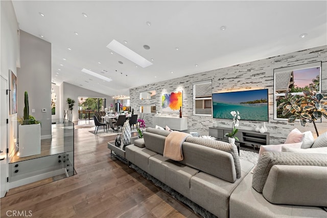 living room with vaulted ceiling, a chandelier, and hardwood / wood-style floors