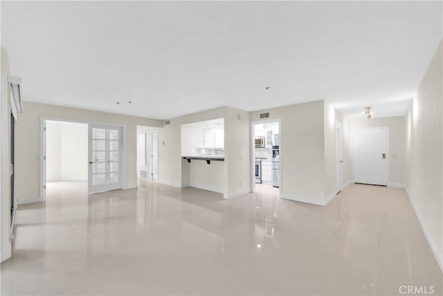 260 Cagney Ln Unit 105, Newport Beach, CA 92663 - unfurnished living room with light tile patterned floors and baseboards