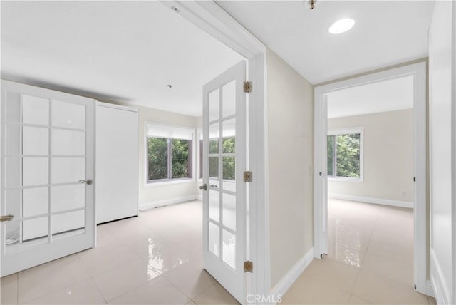 hallway with light tile patterned floors and french doors