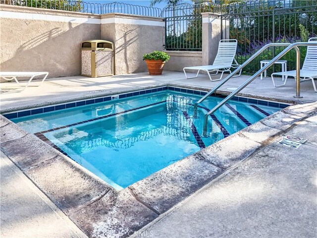 view of swimming pool with a patio area and a hot tub