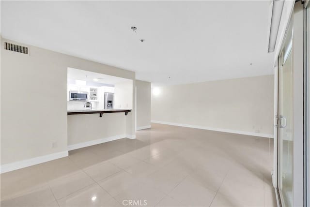 unfurnished living room featuring light tile patterned floors