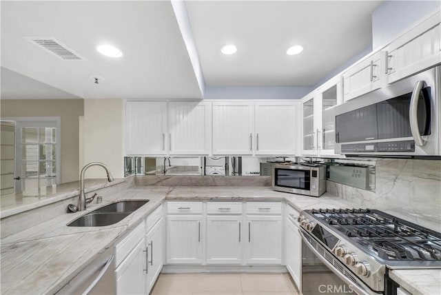 kitchen featuring appliances with stainless steel finishes, sink, light stone counters, and white cabinetry