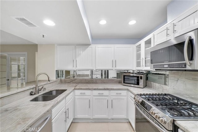 260 Cagney Ln Unit 105, Newport Beach, CA 92663 - kitchen with stainless steel appliances, a sink, light stone countertops, and white cabinets