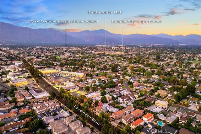 aerial view at dusk featuring a mountain view