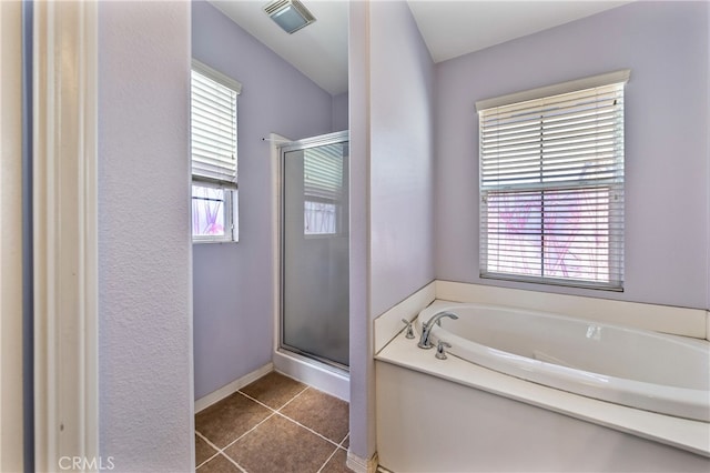 bathroom featuring plus walk in shower, a wealth of natural light, and tile patterned floors