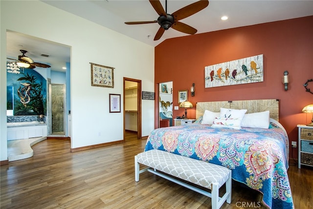 bedroom with vaulted ceiling, hardwood / wood-style floors, ceiling fan, and ensuite bath