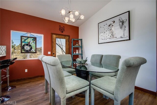 dining space with vaulted ceiling, a chandelier, and dark hardwood / wood-style flooring