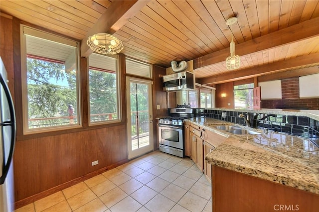 kitchen with sink, beamed ceiling, wood walls, wood ceiling, and appliances with stainless steel finishes