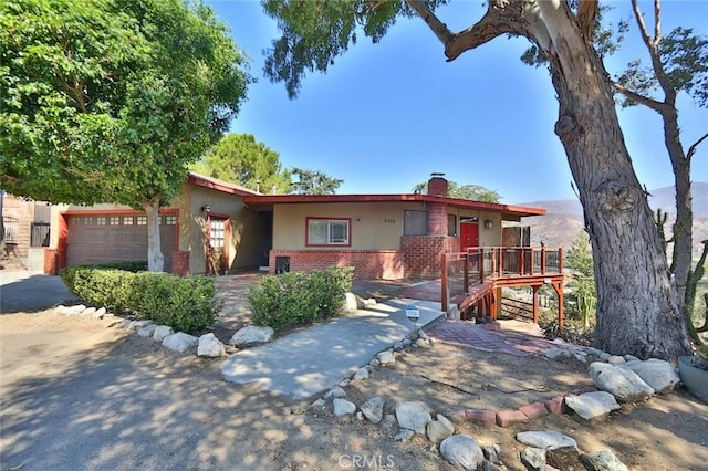 view of front of home with a garage and a deck with mountain view