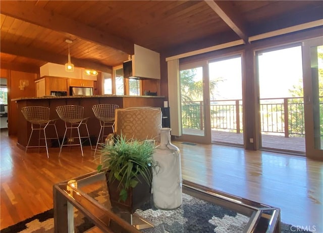 living room with beamed ceiling, light hardwood / wood-style floors, and wood ceiling