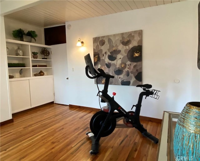 exercise area with wood ceiling and wood-type flooring