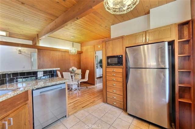 kitchen with light stone countertops, light tile patterned floors, beamed ceiling, decorative light fixtures, and stainless steel appliances