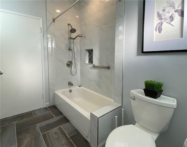 bathroom featuring tiled shower / bath combo and toilet