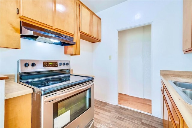 kitchen featuring electric range, sink, and light hardwood / wood-style floors