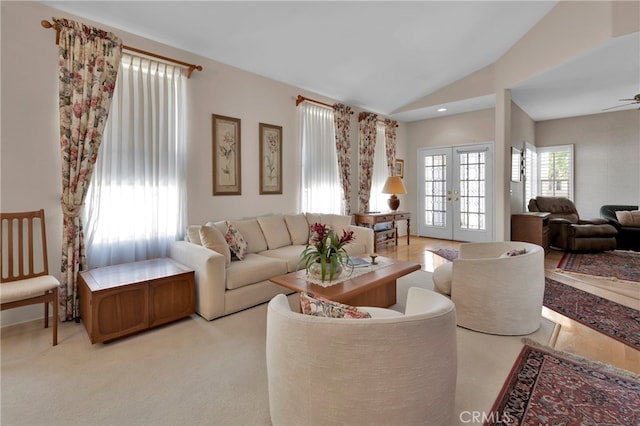 carpeted living room featuring french doors, vaulted ceiling, and ceiling fan