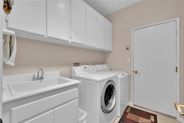 laundry room featuring cabinets, tile patterned flooring, washing machine and dryer, and sink