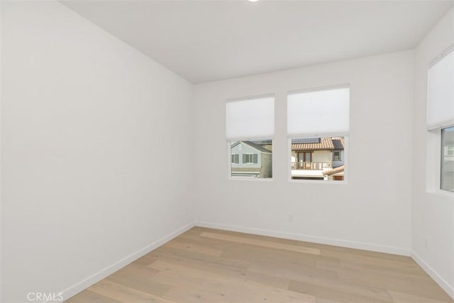 empty room with plenty of natural light and light hardwood / wood-style flooring