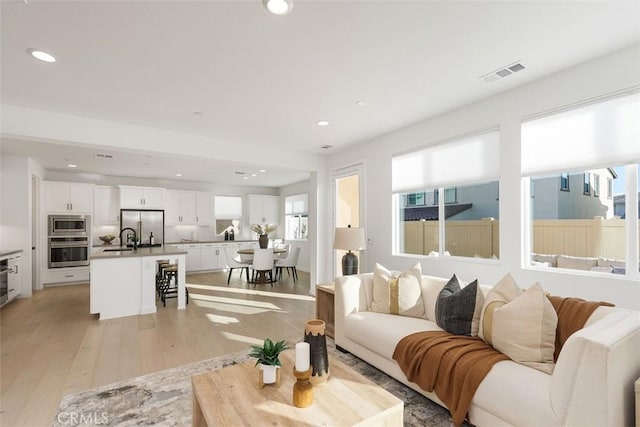 living room with sink and light hardwood / wood-style floors