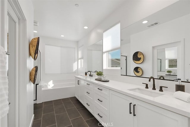 bathroom featuring a tub to relax in, tile patterned floors, and vanity