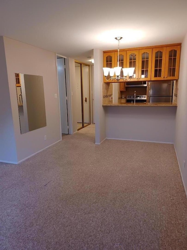 interior space with carpet floors, pendant lighting, and stainless steel appliances