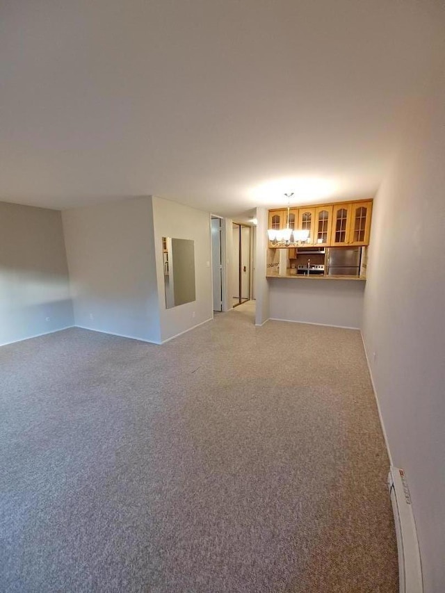 unfurnished living room featuring baseboard heating and carpet