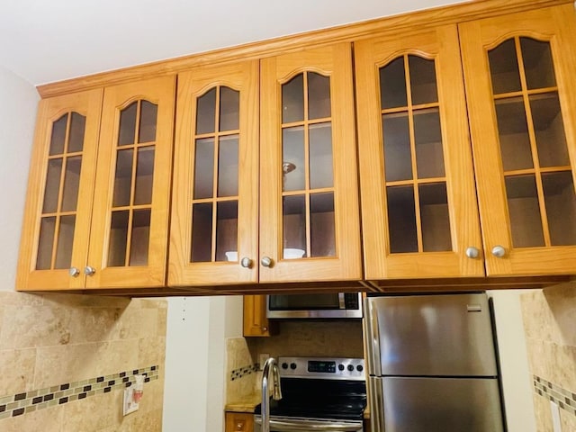 interior details with appliances with stainless steel finishes and tasteful backsplash