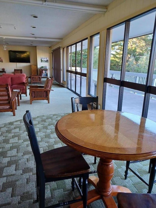 dining room with carpet floors and beamed ceiling