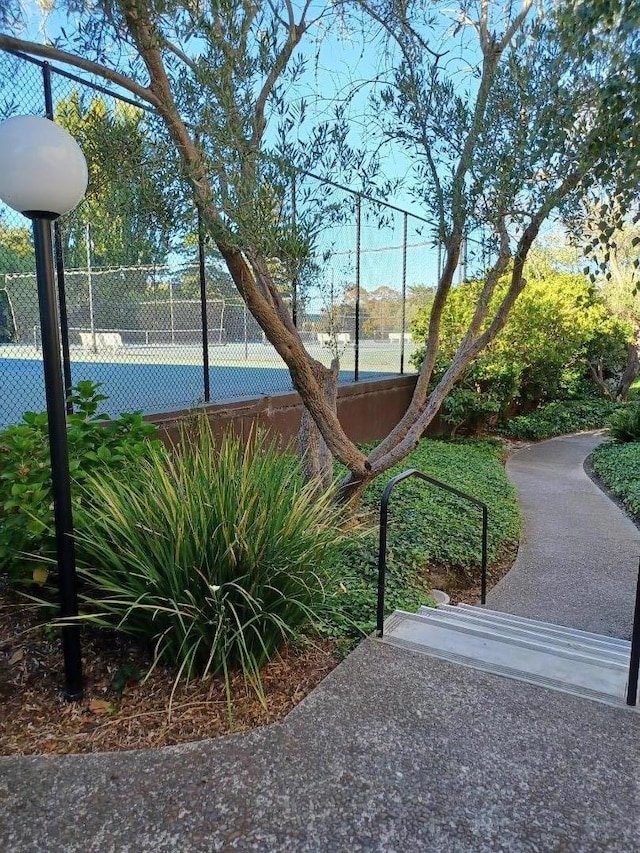 view of home's community with tennis court