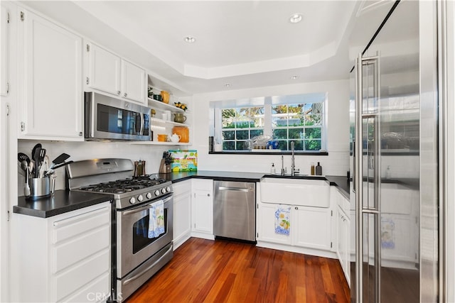 kitchen with white cabinets, appliances with stainless steel finishes, dark wood-type flooring, and sink