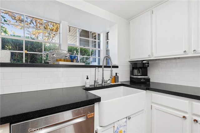 kitchen with stainless steel dishwasher, backsplash, sink, and white cabinetry