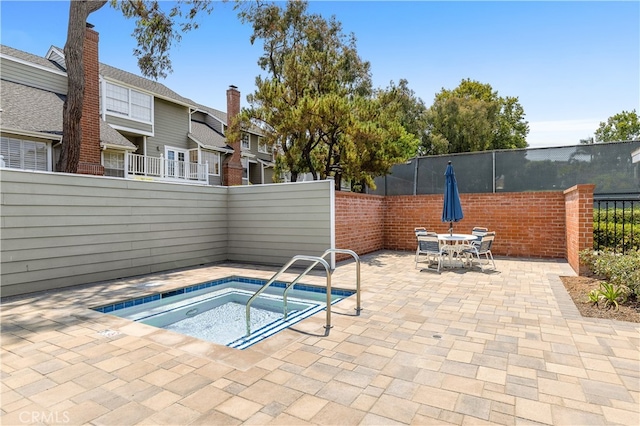 view of swimming pool featuring an in ground hot tub and a patio area