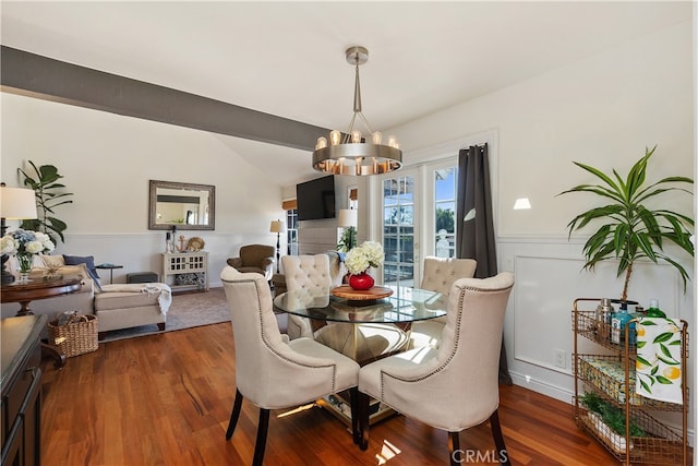 dining room featuring a notable chandelier, lofted ceiling, and dark hardwood / wood-style floors