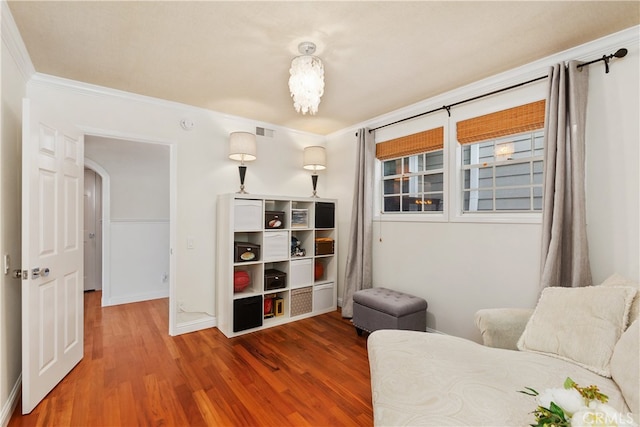 living area with ornamental molding and hardwood / wood-style flooring