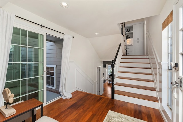 stairs featuring vaulted ceiling and hardwood / wood-style floors