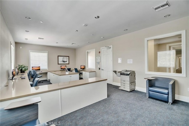 kitchen featuring kitchen peninsula, white cabinets, and dark colored carpet