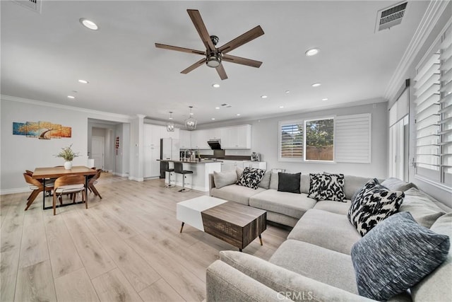 living room with crown molding, light hardwood / wood-style flooring, and ceiling fan