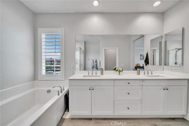 bathroom with wood-type flooring, vanity, and separate shower and tub