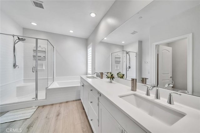 bathroom with vanity, hardwood / wood-style flooring, and separate shower and tub