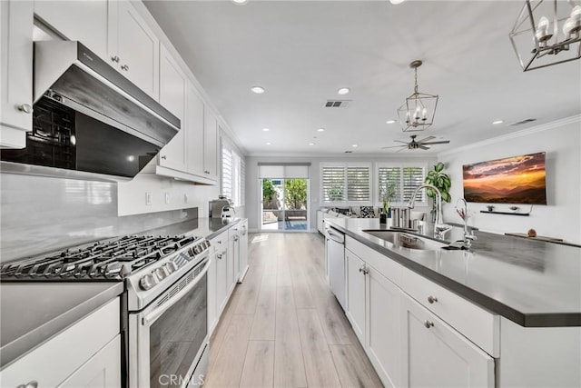 kitchen featuring stainless steel range with gas cooktop, ceiling fan, crown molding, sink, and white cabinetry