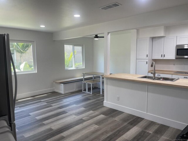 kitchen featuring dark hardwood / wood-style floors, sink, wooden counters, and fridge