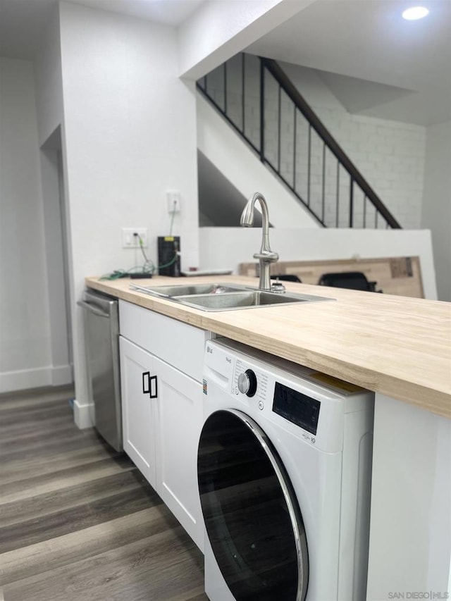 clothes washing area featuring washer / clothes dryer, dark hardwood / wood-style flooring, and sink